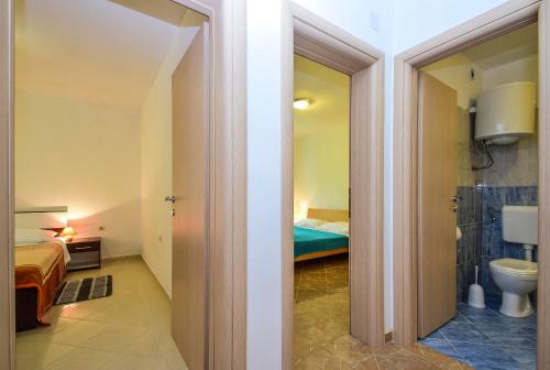 a bathroom with a bed and a toilet in a room at Apartments Komadina 596 in Vlašići