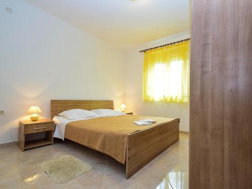 a bedroom with a large bed and a window at Apartments Komadina 596 in Vlašići
