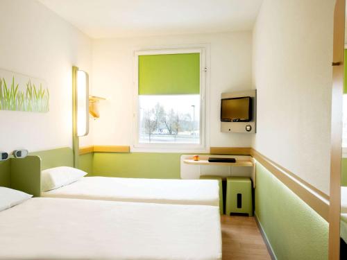 a hotel room with two beds and a window at ibis budget Warszawa Centrum in Warsaw