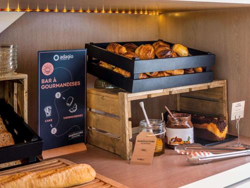 a bakery with lots of loaves of bread on a counter at Aparthotel Adagio Access La Défense - Léonard De Vinci in Courbevoie