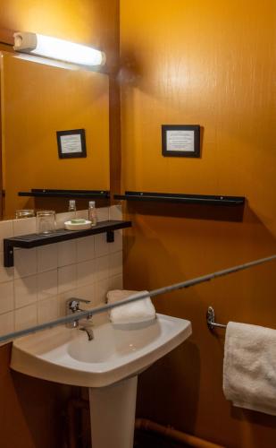 a bathroom with a sink and a mirror at Hotel Auberge des Remparts in Laval