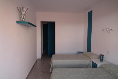 a room with two beds and a couch in it at Hostal San Carlos in Lloret de Mar