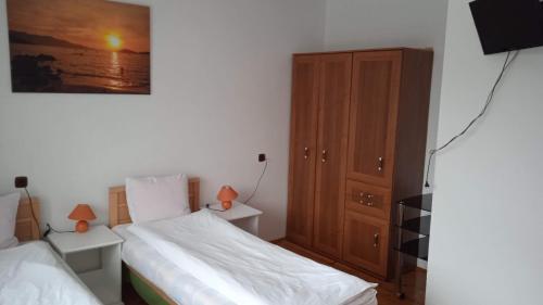 a bedroom with two beds and a wooden cabinet at Królówka in Maków Podhalański