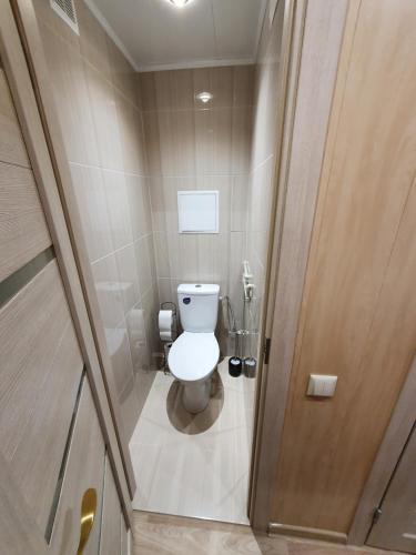 a small bathroom with a toilet and a wooden door at Kreenholm apartments in Narva