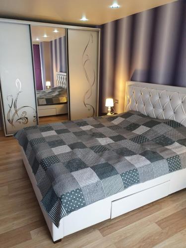 a bedroom with a black and white checkered bed at Kreenholm apartments in Narva