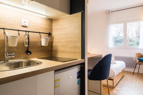 a small kitchen with a sink and a bed at DIFY Charme - Bord du Rhone in Lyon
