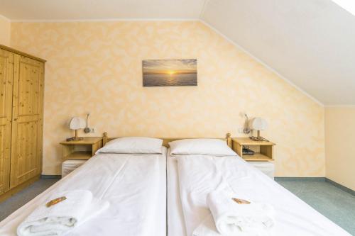 two beds in a room with white sheets at Almsonne in Bad Hindelang