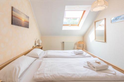 a bedroom with two white beds in a attic at Almsonne in Bad Hindelang