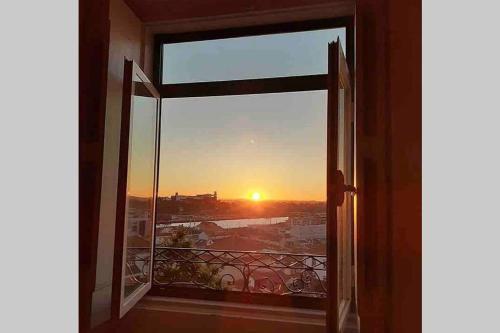 an open window with a view of a sunset at Casa da Carqueja 1 in Coimbra