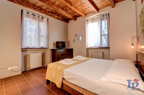a bedroom with a large bed and two windows at DesenzanoLoft: Swarovski in Desenzano del Garda