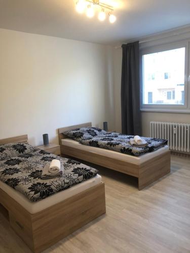 2 Betten in einem Zimmer mit Fenster in der Unterkunft Mountain View Apartment in Štôla