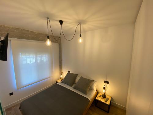 a bedroom with a bed with two pillows and a window at Loft estilo industrial en playa de las marinas!!! in Denia