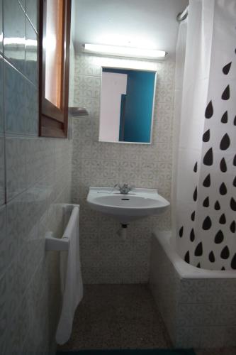 a bathroom with a sink and a shower and a mirror at Hostal San Carlos in Lloret de Mar