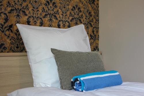 a blue and white pillow on a bed with pillows at Villa Kadriorg Hostel in Tallinn