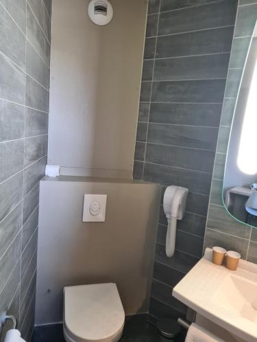 a small bathroom with a toilet and a sink at ibis Montauban in Montauban