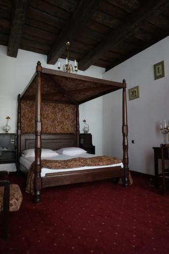 a bedroom with a canopy bed in a room at Hotel Dwór Polski in Wrocław