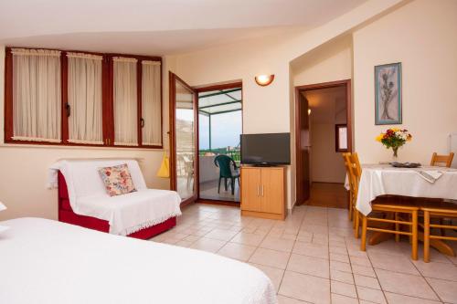 a room with two beds and a television and a table at Apartment Toni 555 in Primošten