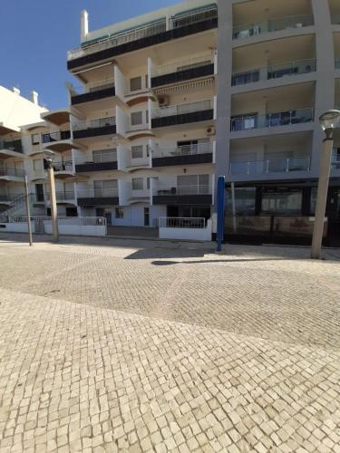 a large apartment building in front of a brick street at Quarteira SeaSide in Quarteira