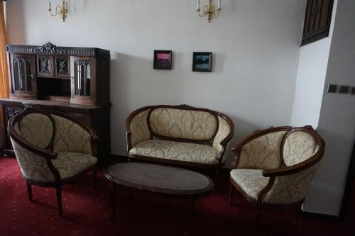 two chairs and a table in a room at Hotel Dwór Polski in Wrocław