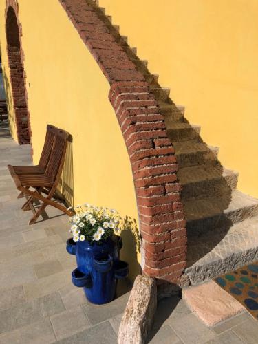 a brick stairway with a vase of flowers and a chair at La Nana Gialla in Riotorto