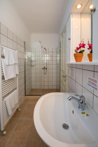 a white bathroom with a sink and a shower at Villa Sofia in Gaios