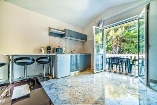 una cocina con armarios azules y una gran ventana en Apartments Ori en Pula