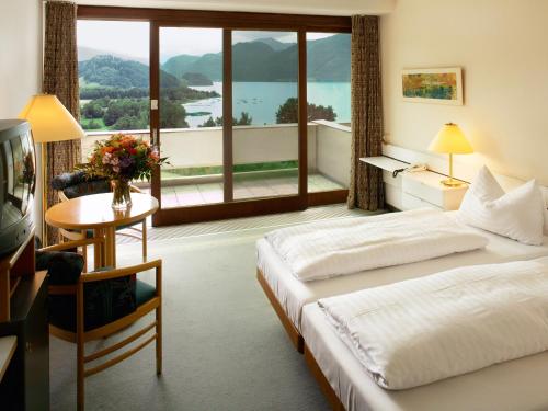 モントゼーにあるLandzeit Motor-Hotel Mondseeのベッド2台と大きな窓が備わるホテルルームです。