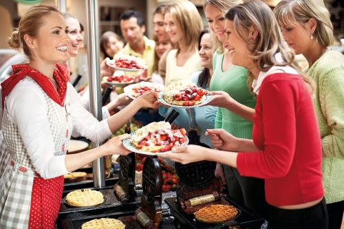 a group of women holding plates of food at Landzeit Motor-Hotel Mondsee in Mondsee