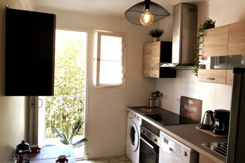 une cuisine avec lave-linge et sèche-linge ainsi qu'une fenêtre dans l'établissement Terrasse plein sud, deux chambres doubles, à Antibes