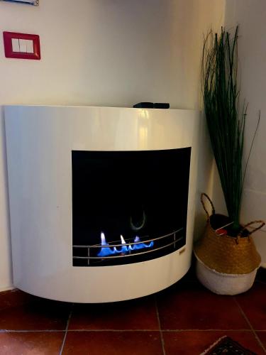 a white fireplace in a room with a plant at Appartamento La Chicca in Sermoneta