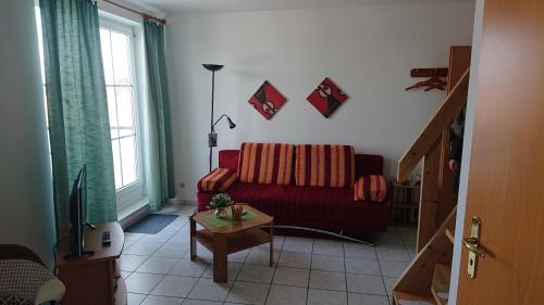 ein Wohnzimmer mit einem roten Sofa und einem Tisch in der Unterkunft Ostseeblick in Insel Poel