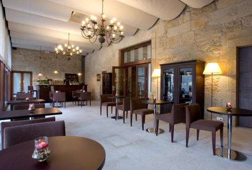 ein Restaurant mit Tischen und Stühlen und einer Bar in der Unterkunft Hotel Pazo de Lestrove by Pousadas de Compostela in Padrón