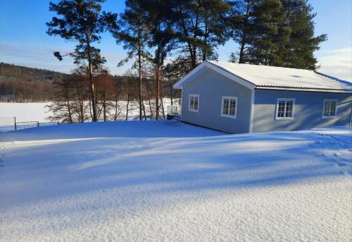 a small white shed in the snow at Przystań na Zagórzu - Apartamenty nad jeziorem in Drezdenko
