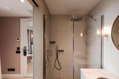 a bathroom with a shower with a glass door at 123 MAINSTREET boutique hotel in St Julian's