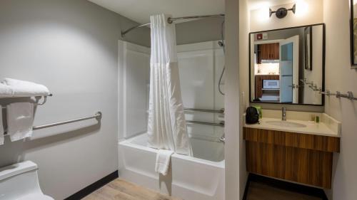 y baño con ducha y lavamanos. en Uptown Suites Extended Stay Charlotte NC - Concord, en Concord