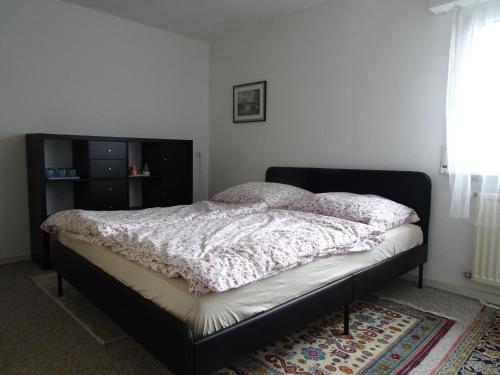 ein Bett in einem Schlafzimmer mit schwarzem Bettgestell in der Unterkunft Haus Fermate in Wilhelmsfeld