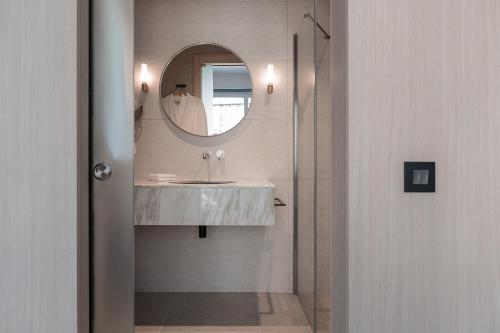 a bathroom with a sink and a mirror at 123 MAINSTREET boutique hotel in St Julian's