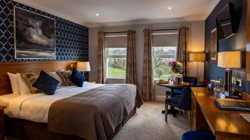 a hotel room with a bed and a desk at The Lakeside Hotel & Leisure Centre in Killaloe