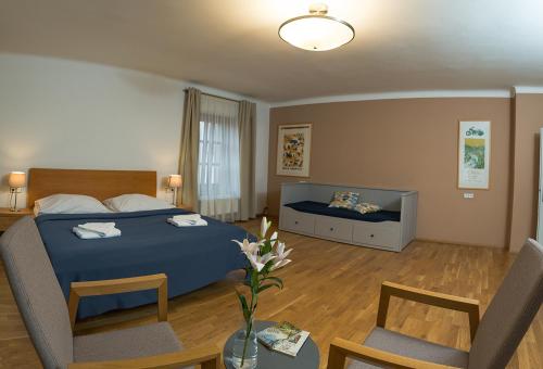 a bedroom with a blue bed and a living room at Penzion THIR in Tábor