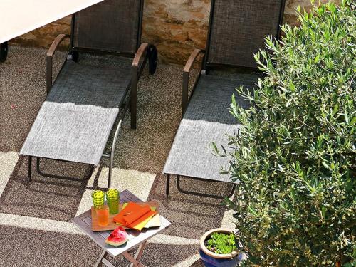 two chairs and a table with drinks on a patio at Le Clos de la Tuilière in Grignan