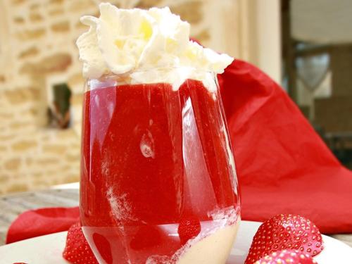 a strawberry milkshake with whipped cream and strawberries on a table at Le Clos de la Tuilière in Grignan