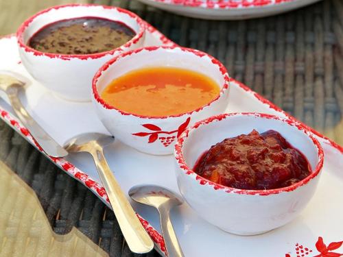 three bowls of soup on a white plate with spoons at Le Clos de la Tuilière in Grignan