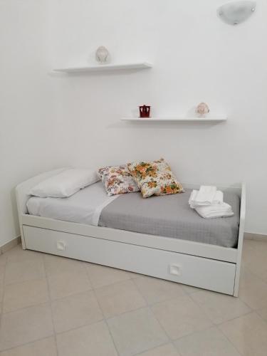 uma cama com duas almofadas num quarto em Casetta Carlotta em Ostuni