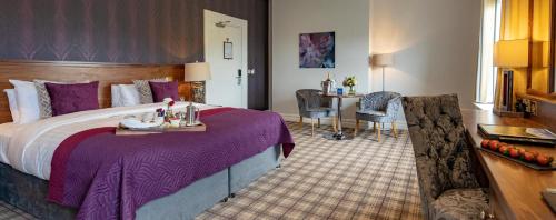 um quarto de hotel com uma cama grande e uma secretária em The Lakeside Hotel & Leisure Centre em Killaloe