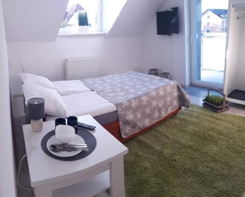 a bedroom with a bed and a table with a table sidx sidx sidx at Azalia 32 Mielno l in Mielno