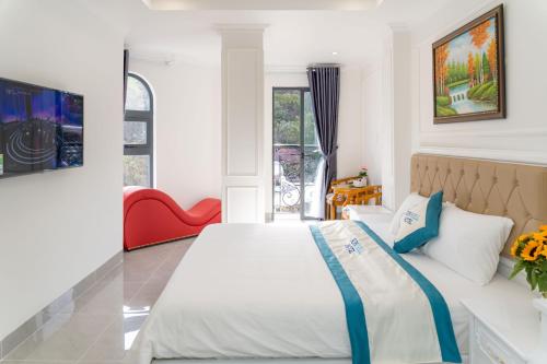 sypialnia z dużym łóżkiem i czerwonym krzesłem w obiekcie Sun Hill Hotel w mieście Vung Tau