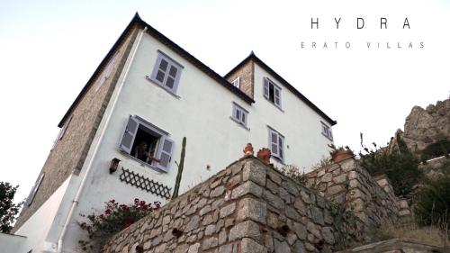 a white house on top of a stone wall at Hydra Erato in Hydra