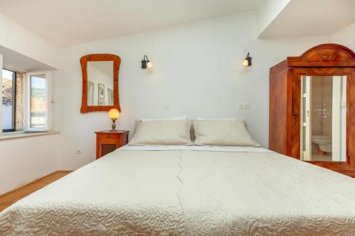 een slaapkamer met een groot wit bed en een spiegel bij APARTMENT PLACA DUBROVNIK 2 in Dubrovnik