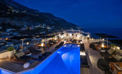 a villa with a swimming pool at night at Hotel Villa Franca in Positano