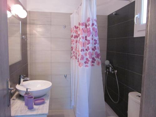 bagno con lavandino e tenda doccia di Petra Houses a Potos